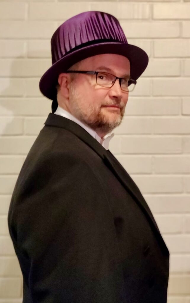 Juha Itkonen kuvattuna sivusta teologian tohtorin hattu päässään